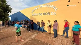 Eleitores aguardam em fila na entrada da Escola Municipal Auta de Souza, em Jataí, antes da abertura da votação no segundo turno das Eleições 2026.